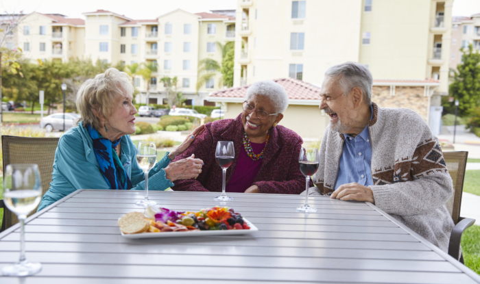 3 residents sit outside for a snack