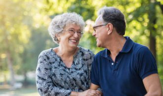 an elderly couple share a moment in a park