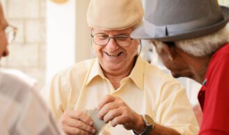 a group of older men play cards