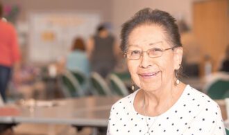 an elderly woman with glasses smiling