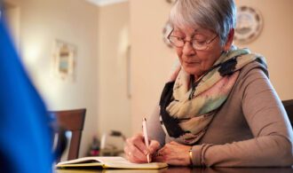 an elderly woman writes in a journal, Assisted Living in National City , California