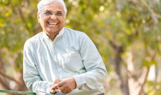 an elderly man in assisted living with white hair smiles widely