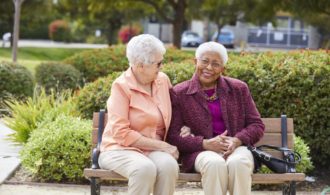 Two ladies sit on a bench at Cherrywood Vilalge in Portland